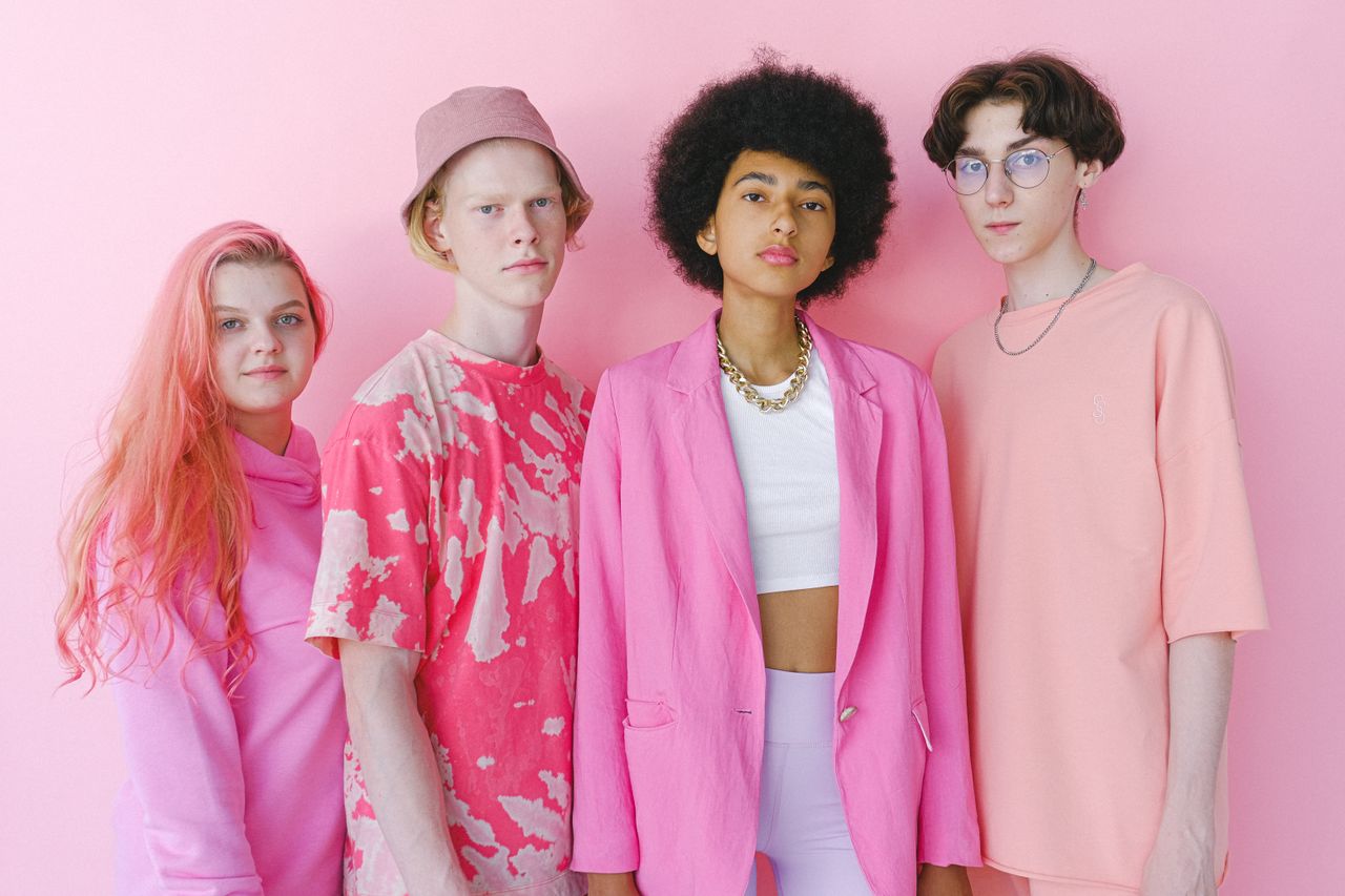 about-01 Diverse teenage friends in trendy outfits looking at camera on pink background of studio
